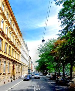 维也纳New Luxury Apartment Vienna的一条街道,汽车停在大楼的一侧