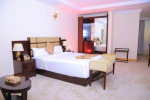 亚的斯亚贝巴Sunland International Hotel的卧室配有一张白色大床和一把椅子