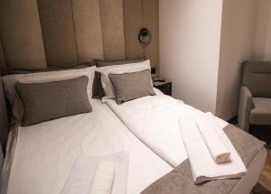 瓦列沃Sunshine apartments - Valjevo的一张大白色的床,位于带椅子的房间