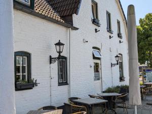 Posterholt罗尔丹兰餐厅酒店的一座配有桌椅的户外庭院和一座建筑