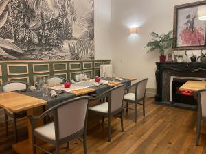 罗克福Le St Vincent的一间带桌椅和壁炉的用餐室