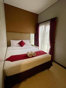 雅加达Griyadi Blue Pacific的一间卧室配有一张床,上面有两条毛巾