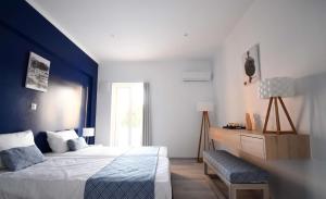 米尔泰Aphrodite Studios Kalymnos的一间卧室设有一张床和蓝色的墙壁
