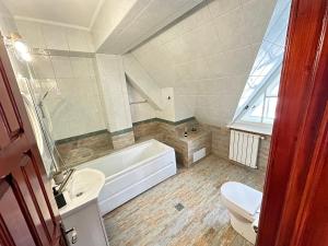 普雷代亚尔Pine Peak Apartments的带浴缸、卫生间和盥洗盆的浴室