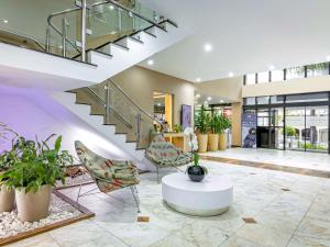 库里提巴库里提巴塞特布鲁美居酒店的大堂设有楼梯、椅子和植物