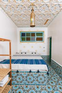 丹吉尔Colorful traditional Riad w/views of Spain的一间卧室设有一张蓝色和白色天花板的床。