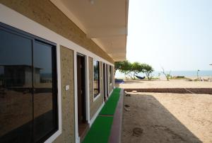 戈卡尔纳Borrbo Beach Hostel Gokarna的海滩旁的绿色人行道建筑