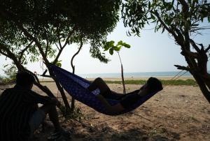戈卡尔纳Borrbo Beach Hostel Gokarna的躺在海滩上吊床上的女人