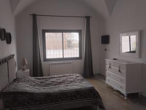 哈马马特Duplex Hammamet的一间卧室配有一张床、一个梳妆台和一扇窗户。
