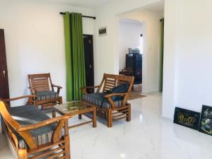 坦加拉Star Beach Villa的客厅配有三把椅子和一张桌子