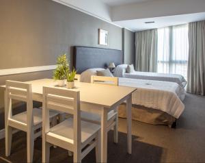 圣路易斯Visit Hotel & Apart的酒店客房设有一张桌子和一张床