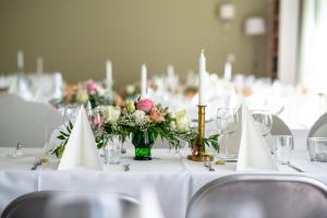 LängelmäkiVilla Puharila的一张桌子,上面有白色的桌子,上面有鲜花和蜡烛