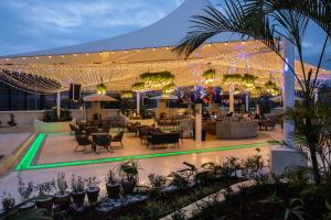 内罗毕内罗毕机场雅阁大酒店的户外庭院配有桌椅和灯光