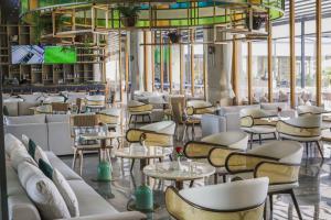 内罗毕内罗毕机场雅阁大酒店的一间带白色椅子和桌子的餐厅