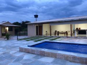 皮雷诺波利斯Chalé sossego的一个带游泳池和房子的后院