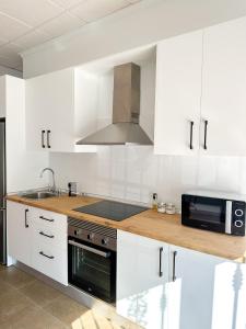 ZurgenaCasa Primavera的厨房配有白色橱柜、水槽和微波炉