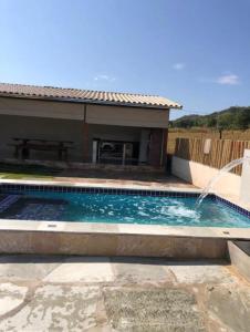 皮雷诺波利斯Chalé sossego的一座房子前面带喷泉的游泳池