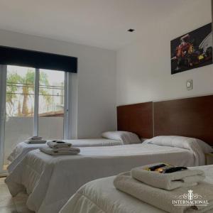 特尔马斯德里奥翁多Hotel internacional的一间设有三张床的客房,备有毛巾