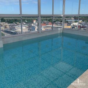 特尔马斯德里奥翁多Hotel internacional的一座大型游泳池,位于一座带窗户的建筑内