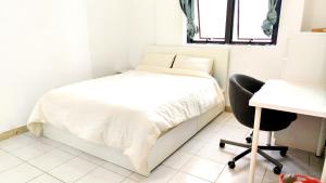 阿布扎比Ms. Zhang Apartment的一间卧室配有一张床、一张桌子和一把椅子