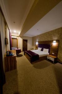 巴库Royal Boutique Baku的酒店客房设有一张大床和一张桌子。