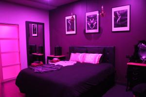 弗卢瓦拉克SECRET33的紫色卧室配有粉红色照明床