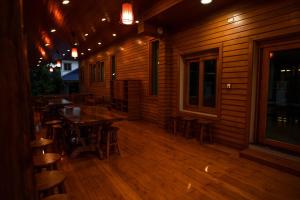 HUAN CHOM JAN Hometel at Lampang的木甲板上设有桌子和凳子的餐厅