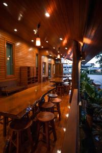 HUAN CHOM JAN Hometel at Lampang的餐厅内带木桌椅的酒吧