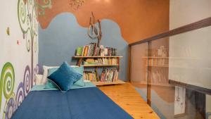 萨迈帕塔Casa Samai Boutique的一间卧室配有一张蓝色的床和书架