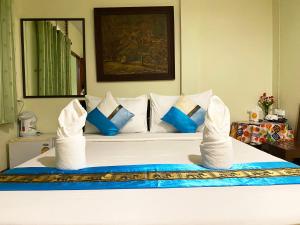蔻立考拉城市大酒店的一间卧室配有一张带蓝色和白色枕头的床