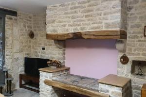 Balnot-sur-LaignesCHEZ MARGARET的客厅设有石墙和石头壁炉