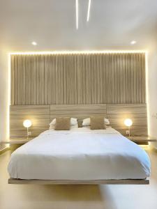 阿比让Appartement Palms Abidjan的一间卧室配有一张带两盏灯的大型白色床。