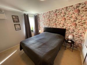 玛丽斯塔德Bakgårdens Vandrarhem的一间卧室配有一张带花卉壁纸的床