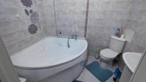 PrigorodnyyKamal Apart的浴室配有白色浴缸和卫生间。