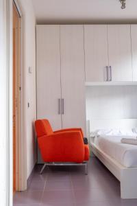克雷马Casa Moro的卧室配有一张位于床边的橙色椅子