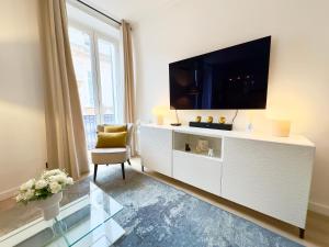 戛纳Luxueux 3 pièces 80m2 - Espace bureau -1mn Beach Croisette的一间客厅,在白色的橱柜上配有电视