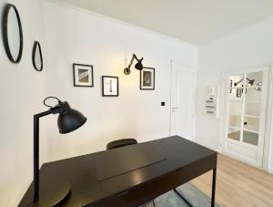 戛纳Luxueux 3 pièces 80m2 - Espace bureau -1mn Beach Croisette的一张黑色的桌子,上面有黑灯,放在白色的墙上