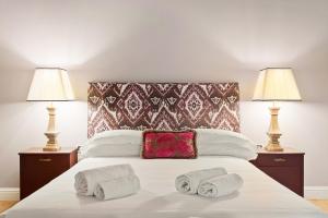 佛罗伦萨Tornabuoni Living - Luxury Apartments Collection的一间卧室配有一张带两盏灯和两条毛巾的床。