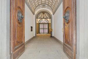 佛罗伦萨Tornabuoni Living - Luxury Apartments Collection的走廊,大楼内有两个大木门