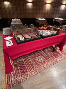 香槟沙隆波特戴塔尹酒店的一张桌子,上面有粉红色的桌布,上面有食物