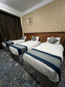 麦加فندق إي دبليو جي العزيزية的一间酒店客房,内有三张床