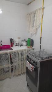 波哥大El descanso的厨房配有炉灶和带窗帘的桌子