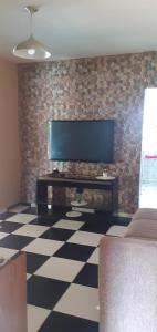 瓜鲁柳斯Sitio Terra Azul的一间客厅,在砖墙上配有平面电视