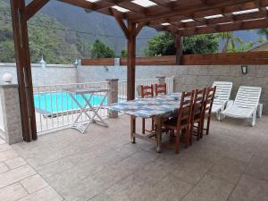 锡拉奥Chez Guy et Josiane的一个带桌椅的庭院和一个游泳池