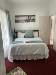 马盖特Dwengu Guest house的一间卧室配有一张带白色床单的大床