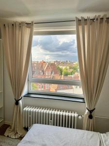 汉诺威Elegantes & Modernes Messe Apartment, Hannover, Laatzen的一间卧室设有窗户,配有窗帘和散热器
