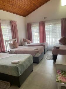 马盖特Dwengu Guest house的带窗户的客房内设有三张床。