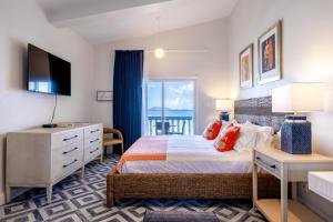 罗得城塞巴斯蒂安海滩酒店的一间卧室配有一张床、一张书桌和一个窗户。
