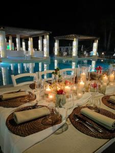 加利波利Borgo Rosso Terra的游泳池畔的一张桌子,上面摆放着蜡烛和椅子