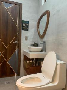 奥塔瓦洛Hotel Sacha Golden的浴室设有卫生间、水槽和镜子